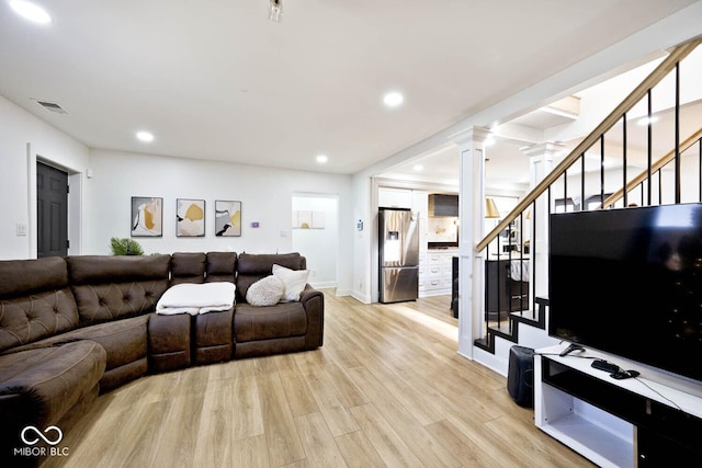 living room featuring light hardwood / wood-style flooring and ornate columns