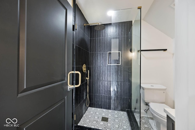 bathroom featuring tile patterned floors, toilet, and a shower with shower door