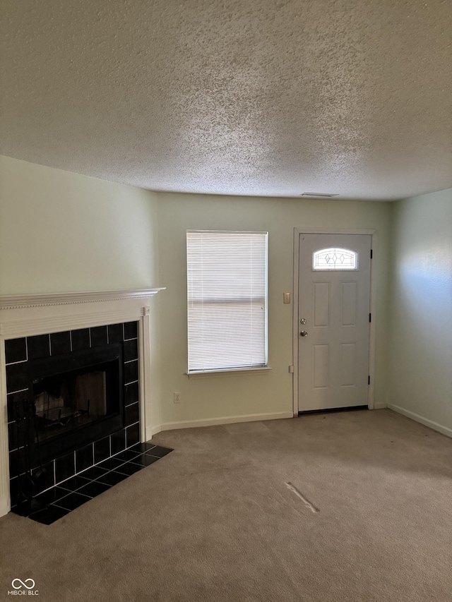 5283 Tufton Dr, Indianapolis, IN 46254 - entrance foyer with carpet flooring, a tile fireplace, and a textured ceiling