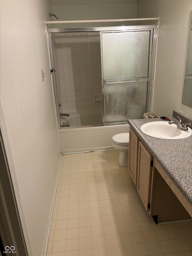 full bathroom with shower / bath combination with glass door, vanity, tile patterned floors, and toilet