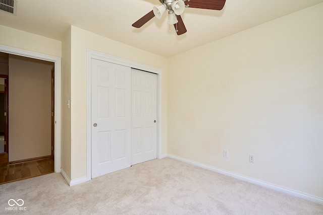 unfurnished bedroom featuring light carpet, a closet, and ceiling fan