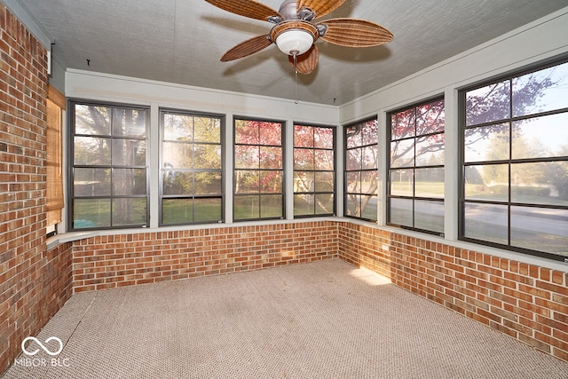 unfurnished sunroom with ceiling fan and plenty of natural light