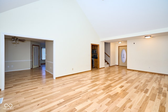 unfurnished living room featuring light wood-type flooring, high vaulted ceiling, and ceiling fan