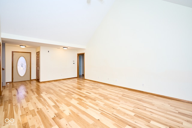 unfurnished living room featuring high vaulted ceiling and light wood-type flooring