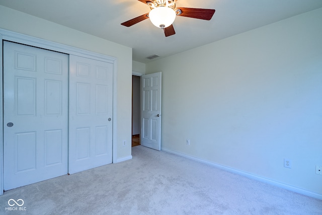 unfurnished bedroom with ceiling fan, a closet, and light carpet