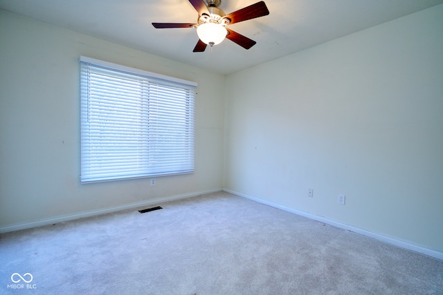 carpeted spare room featuring ceiling fan