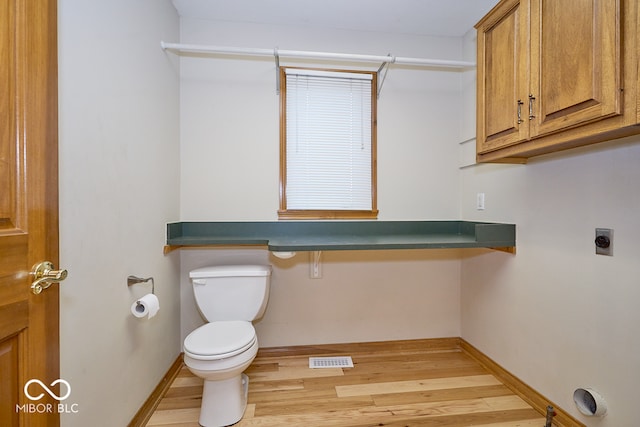 bathroom with hardwood / wood-style floors and toilet