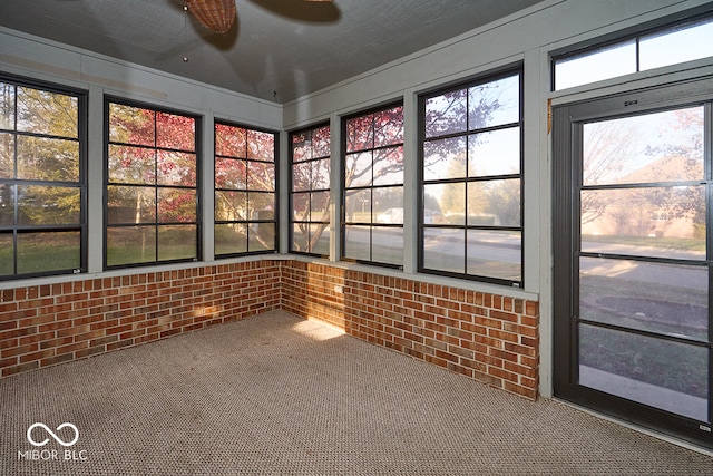 unfurnished sunroom with ceiling fan