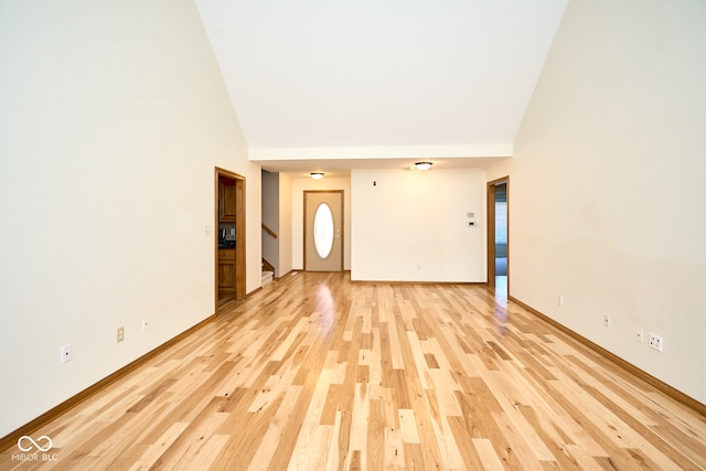 interior space featuring light wood-type flooring and high vaulted ceiling