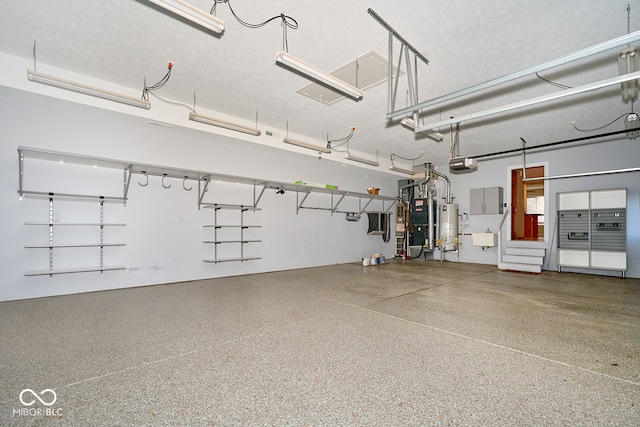 garage with sink, a garage door opener, and water heater