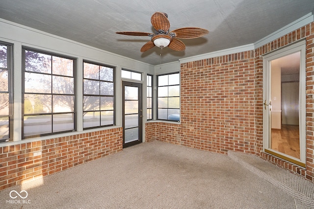 unfurnished sunroom featuring ceiling fan