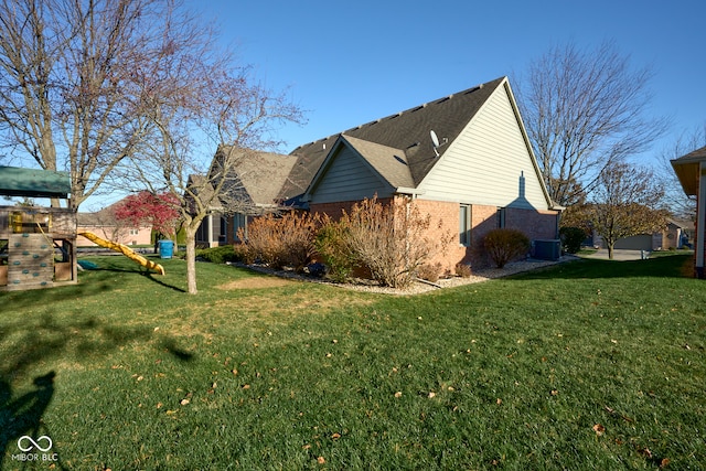 view of property exterior featuring a playground, a yard, and central AC unit