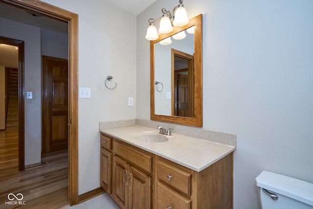 bathroom featuring vanity, wood-type flooring, and toilet