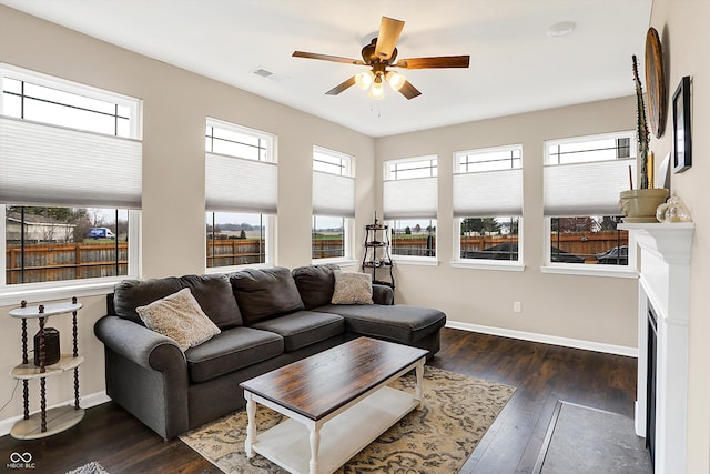 living room with ceiling fan, a healthy amount of sunlight, and dark hardwood / wood-style floors