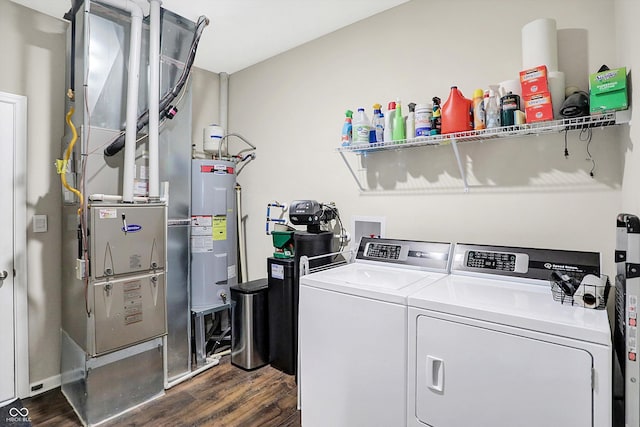 washroom featuring washing machine and clothes dryer, dark hardwood / wood-style floors, and water heater