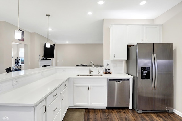 kitchen with appliances with stainless steel finishes, dark hardwood / wood-style flooring, sink, white cabinetry, and hanging light fixtures