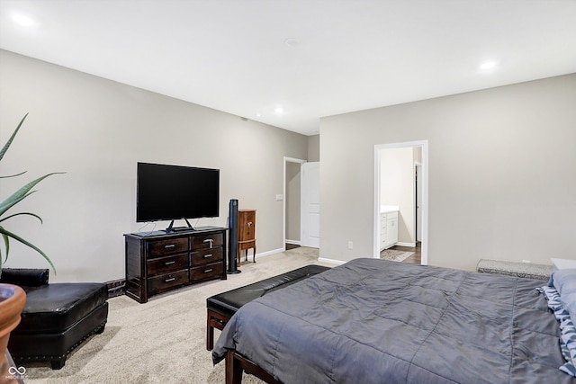 bedroom with light colored carpet and ensuite bath