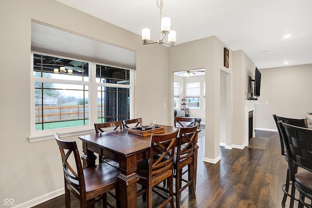 dining space featuring plenty of natural light, dark hardwood / wood-style flooring, and ceiling fan with notable chandelier