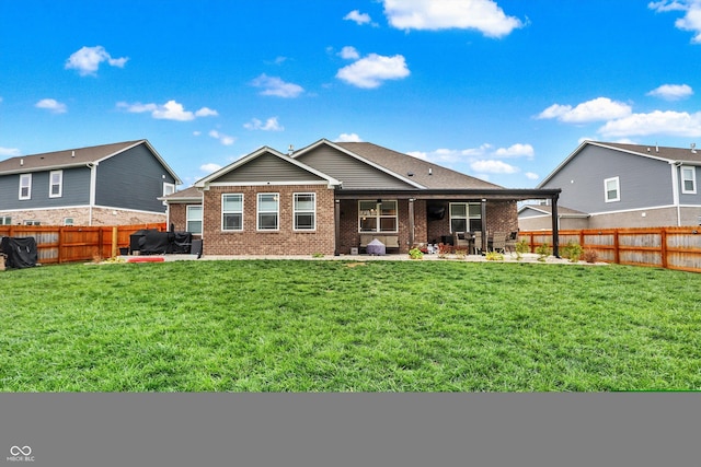 rear view of house with a lawn and a patio