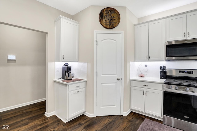 kitchen with white cabinets, dark wood-type flooring, appliances with stainless steel finishes, and tasteful backsplash