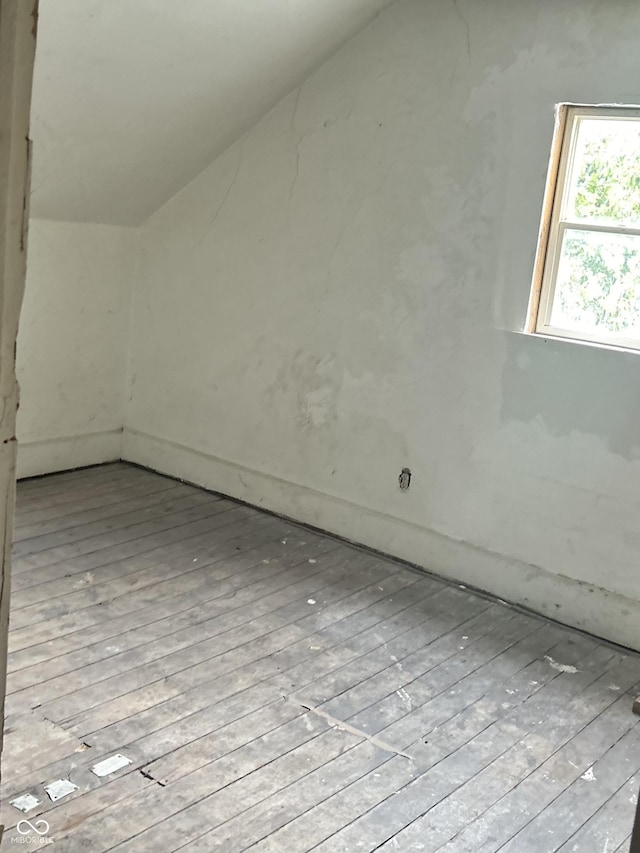 additional living space with lofted ceiling and light hardwood / wood-style flooring