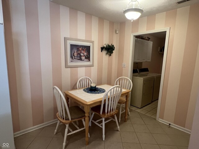 tiled dining room featuring washer and dryer and a textured ceiling