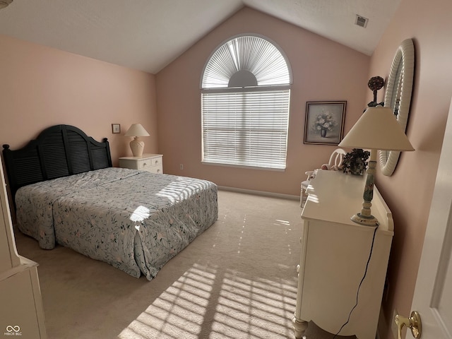 bedroom featuring light colored carpet and lofted ceiling