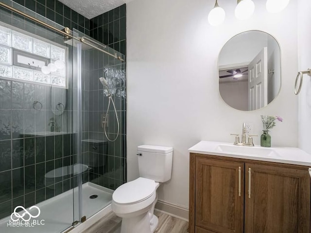 bathroom with hardwood / wood-style floors, toilet, an enclosed shower, and vanity