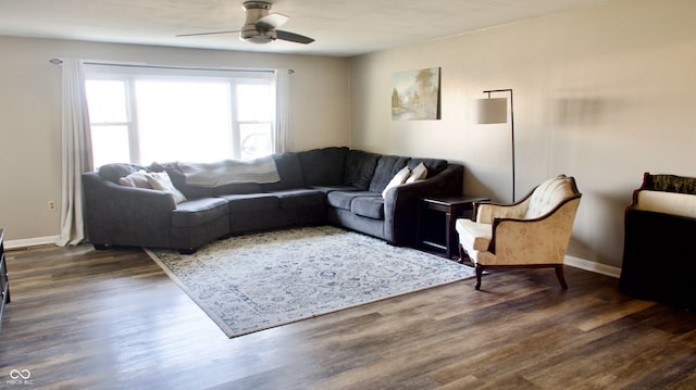 living room featuring ceiling fan and dark wood-type flooring