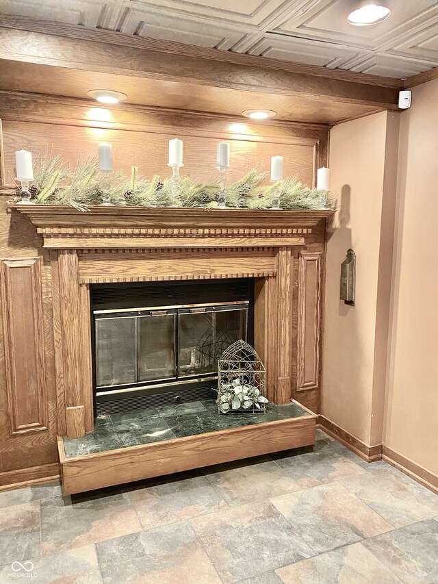 details featuring a glass covered fireplace, baseboards, and an ornate ceiling