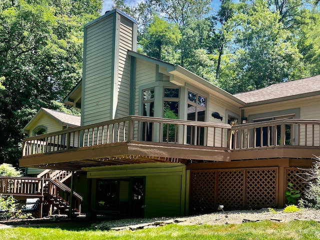 rear view of house with stairway, a deck, and a shingled roof