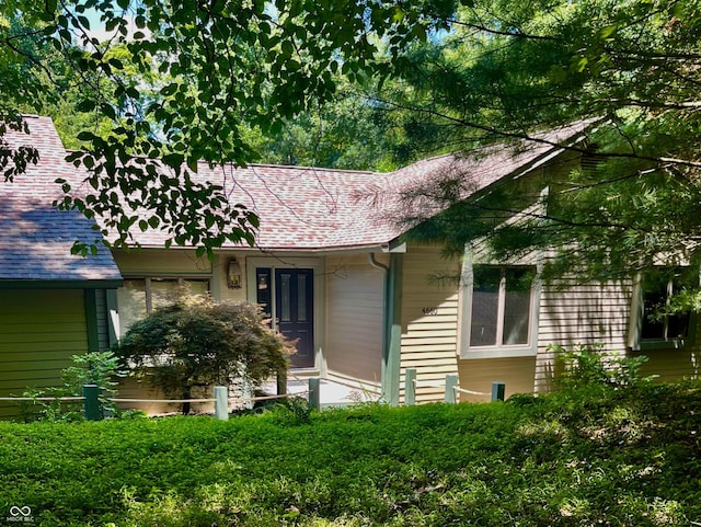 exterior space featuring roof with shingles