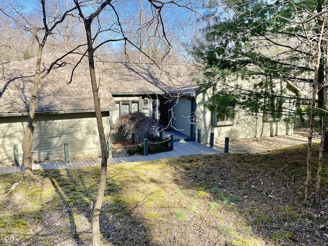 exterior space featuring roof with shingles