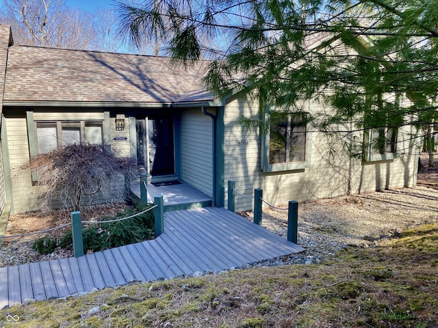 exterior space featuring a deck and a shingled roof