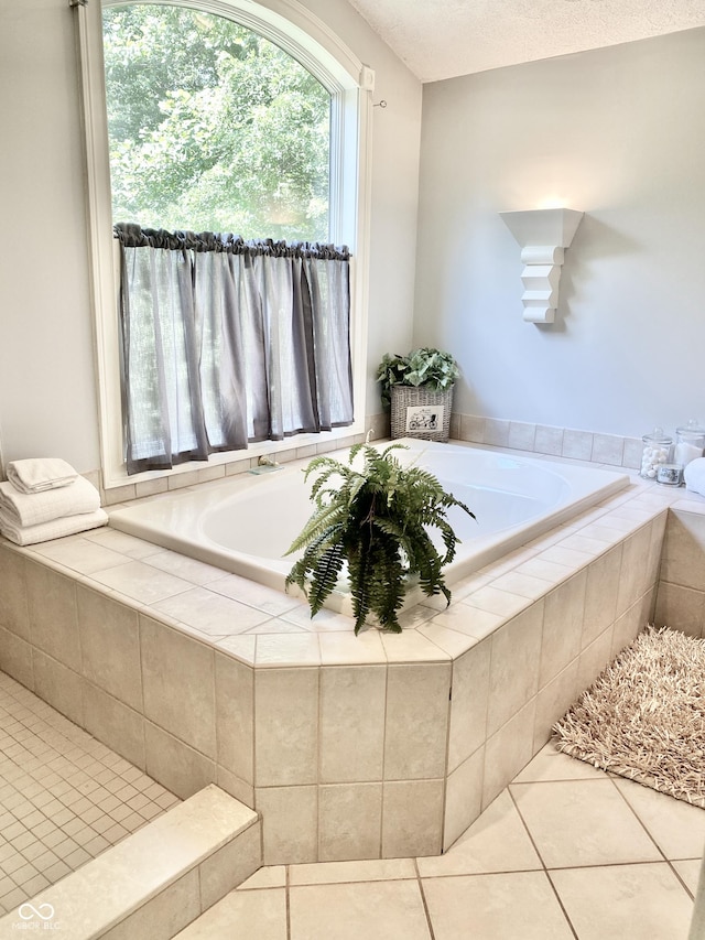 bathroom with tile patterned floors, a textured ceiling, and a bath