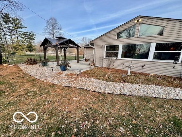 view of property exterior with a yard, a gazebo, and a patio