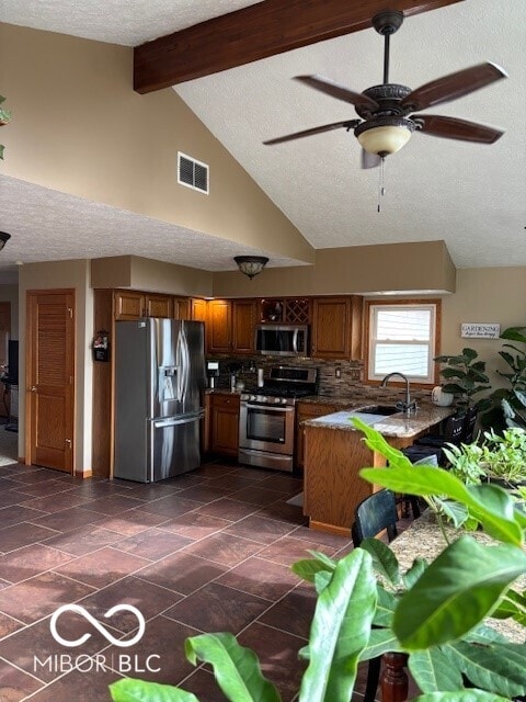 kitchen with sink, ceiling fan, stainless steel appliances, a textured ceiling, and beamed ceiling