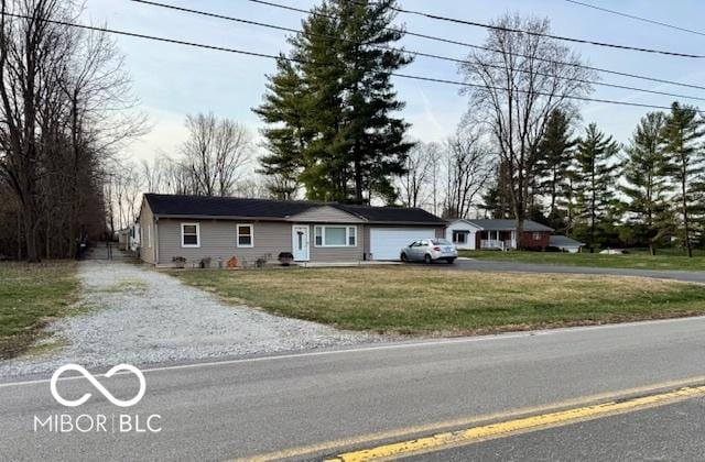 single story home featuring a garage and a front lawn