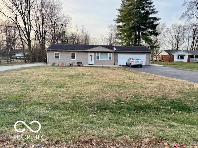 single story home featuring a front lawn and a garage