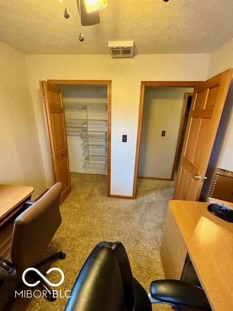 home office featuring a textured ceiling and carpet flooring