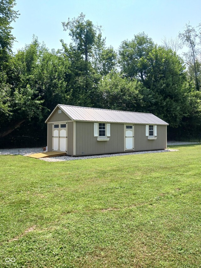 view of outdoor structure with a garage and a lawn