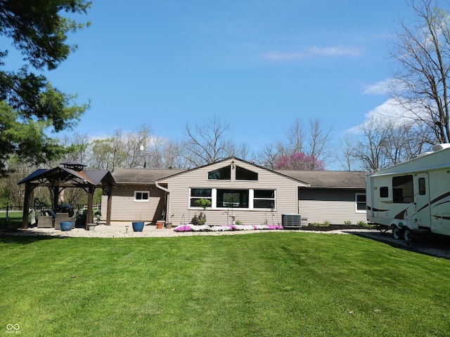 rear view of house featuring a gazebo, cooling unit, and a lawn