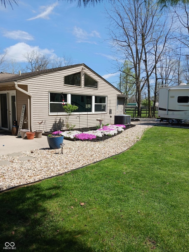 back of house with central AC and a lawn