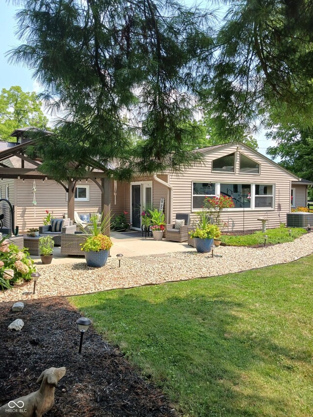 back of house with a patio, outdoor lounge area, and a lawn