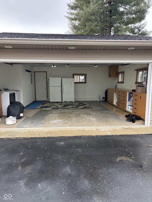 garage with a carport and white fridge