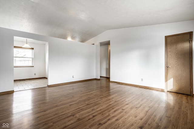 empty room featuring lofted ceiling and dark wood-type flooring