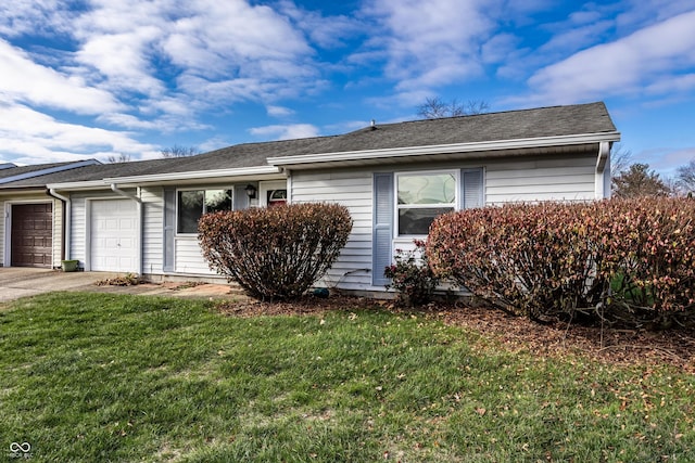 ranch-style house with a garage, a front yard, and concrete driveway