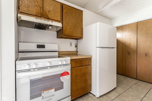 8016 Minlo Dr, Indianapolis, IN 46227 - kitchen featuring white appliances, under cabinet range hood, light tile patterned floors, and brown cabinets