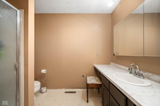 bathroom featuring vanity, toilet, a textured ceiling, and walk in shower