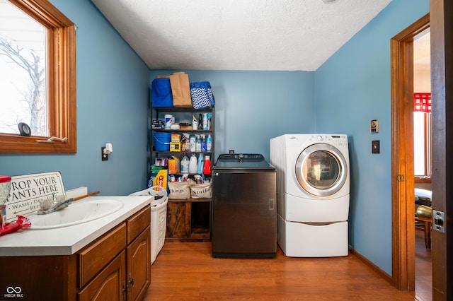 laundry area featuring independent washer and dryer, dark hardwood / wood-style flooring, sink, and a textured ceiling